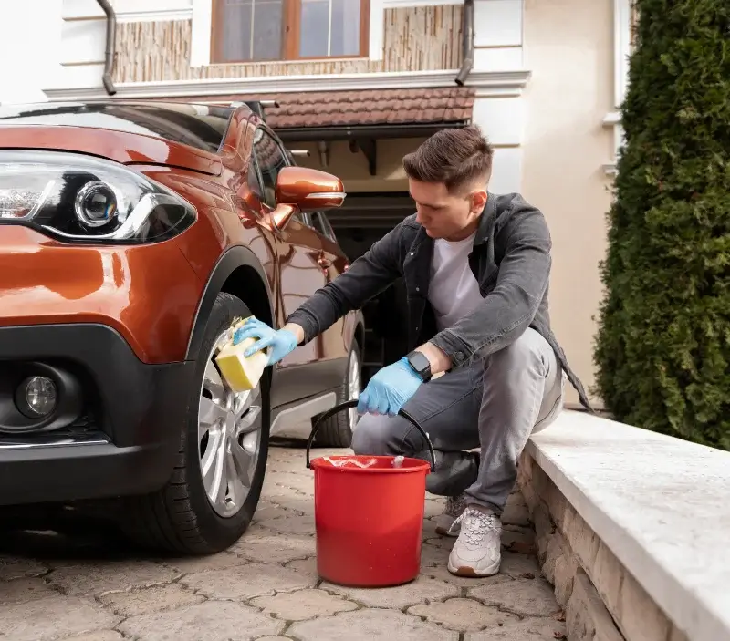 Lavage auto à domicile Port-en-Bessin-Huppain : professionnel intervenant sur un véhicule